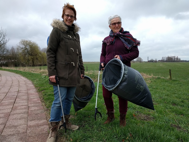 Ria en Martine met grijpstok en vuilniszak